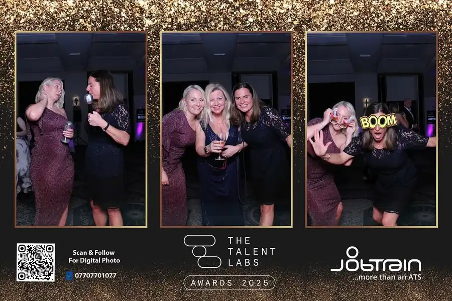 Three women posing together at a party photo booth