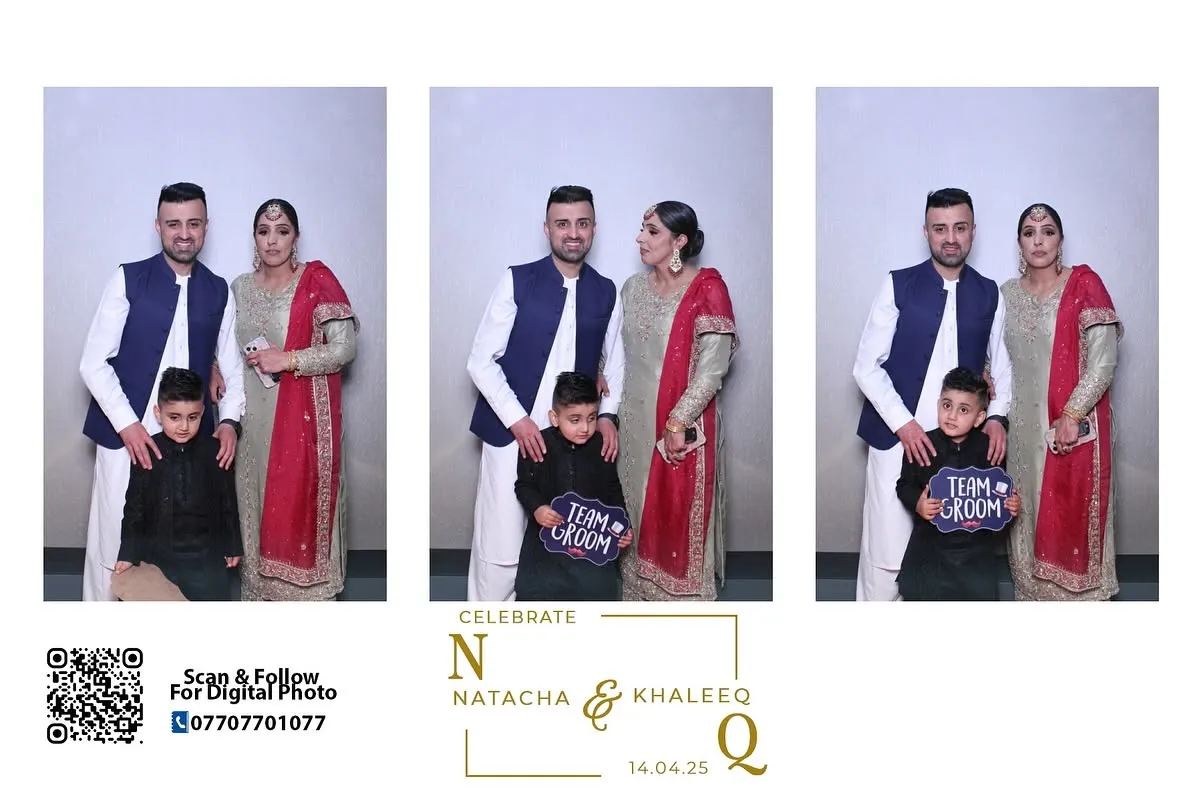 Couple and child posing in wedding outfits at a photo booth