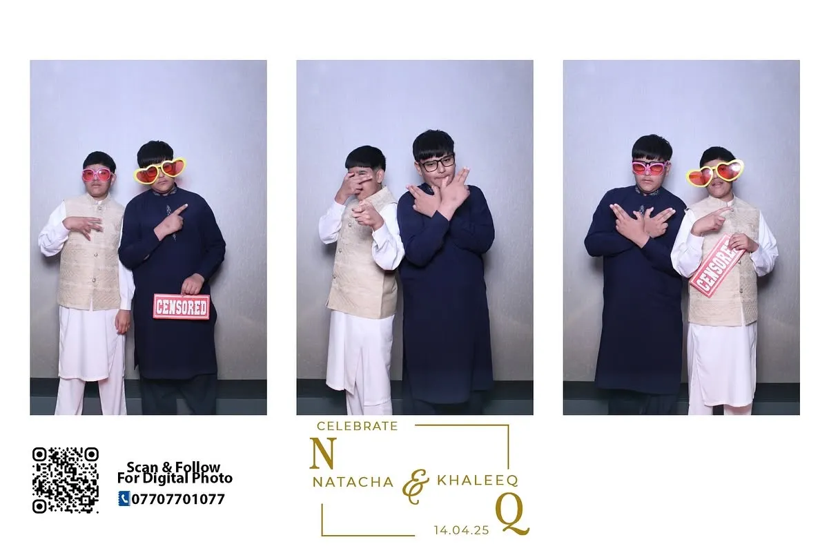 Two young guests posing with props in a Magic Mirror photo booth