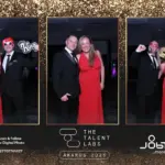 Guests in formal outfits posing in a photo booth frame