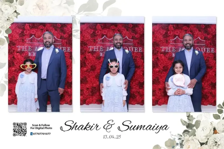 Man and children posing in front of a red wedding photo booth backdrop
