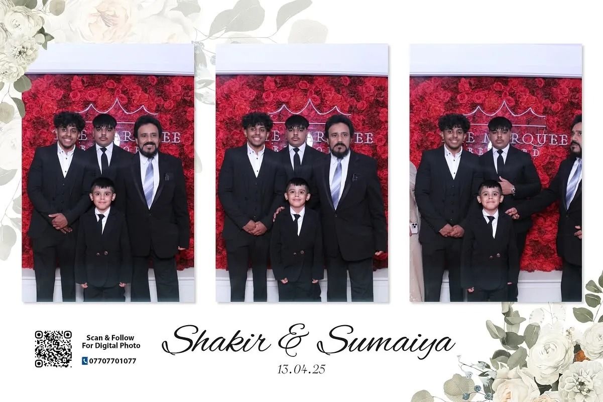 Man and children posing in front of a red engagement party photo booth backdrop