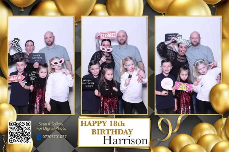 Wedding guests posing in a photo booth with a gold backdrop