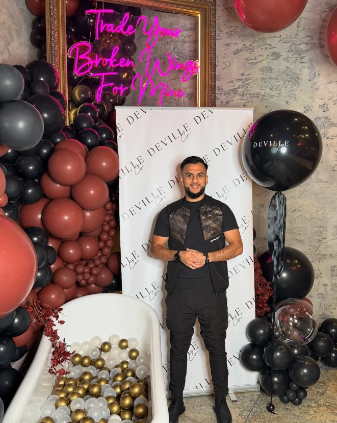 photo of owner of magic mirror photo booth standing in front of booth setup